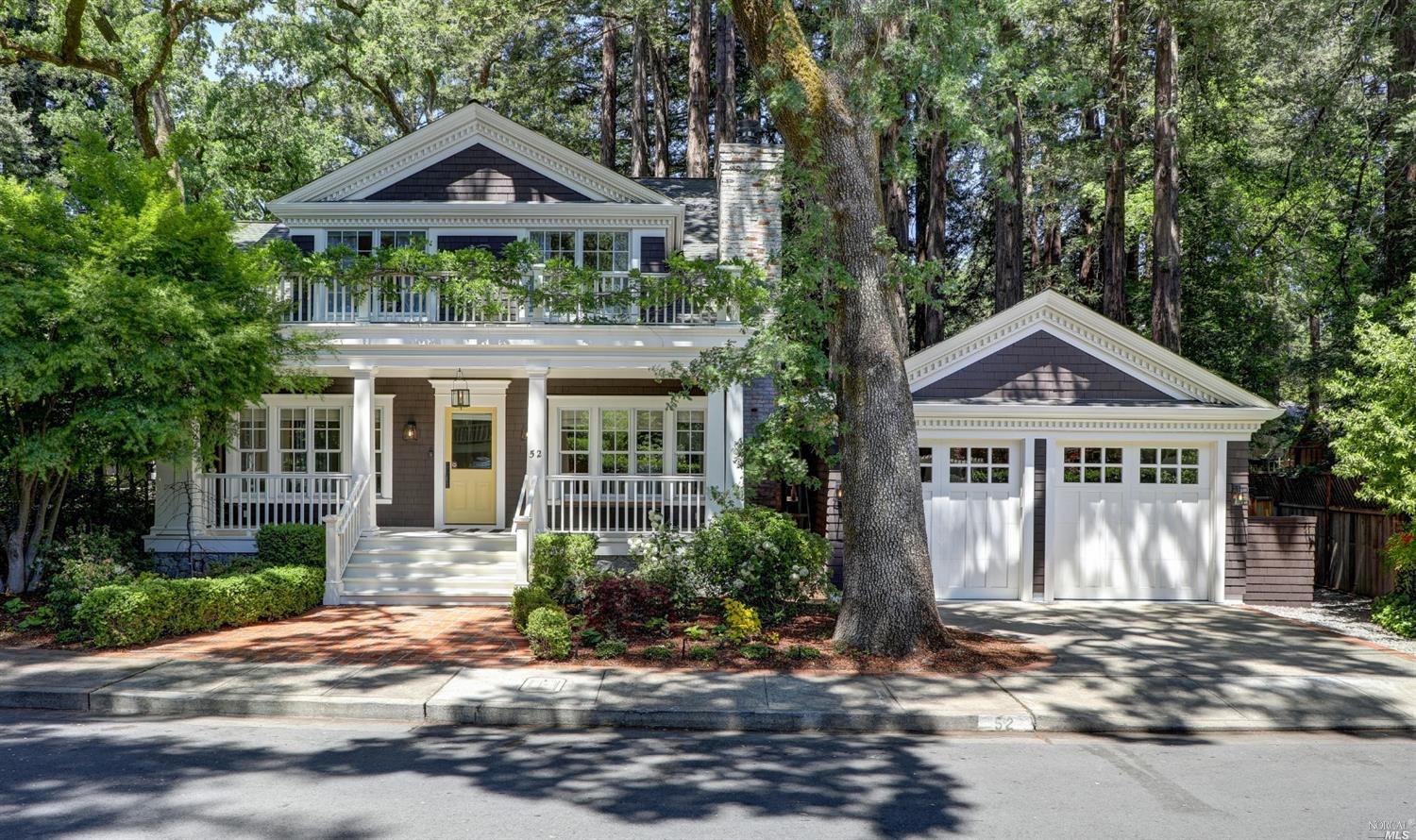 a front view of a house with a yard and potted plants