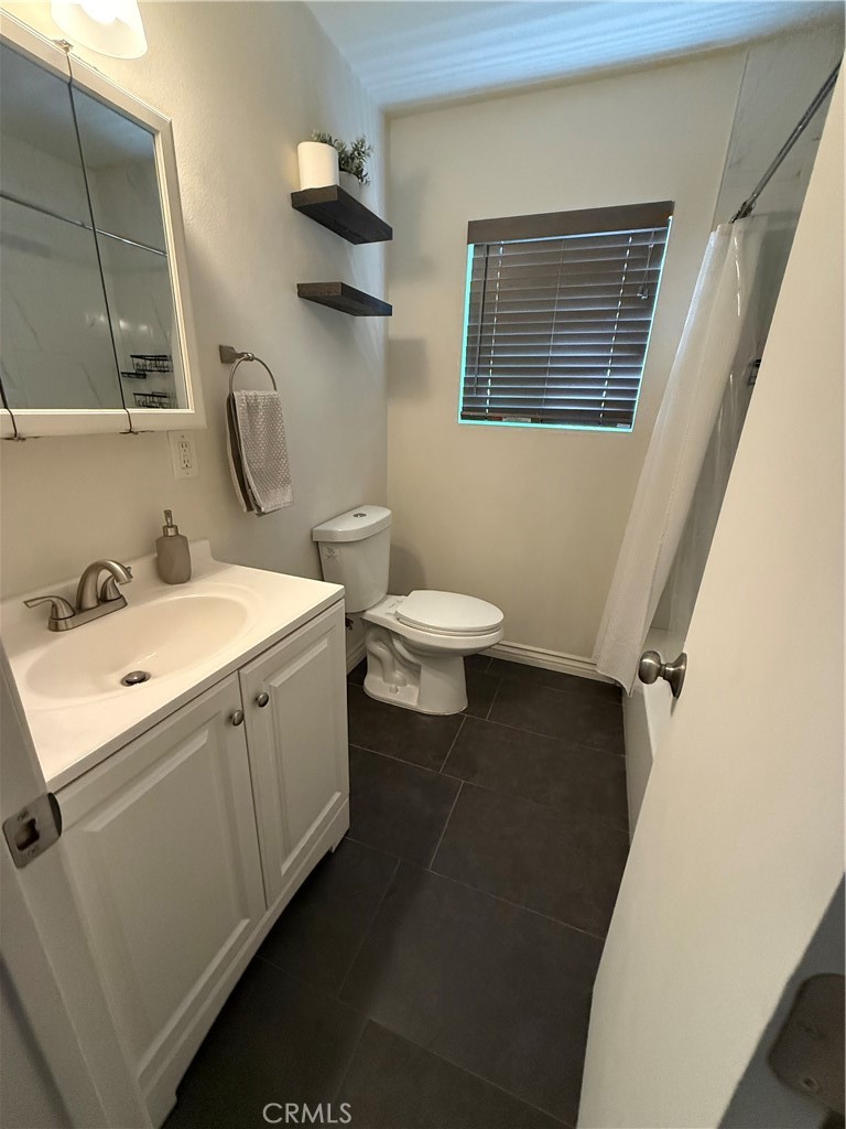 455 East Wilson Street Rialto, CA 92376 - Photo 3 of 8 Full bathroom with tub, shower head, sink, and toilet.