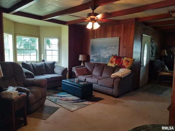 a living room with furniture a chandelier and a window