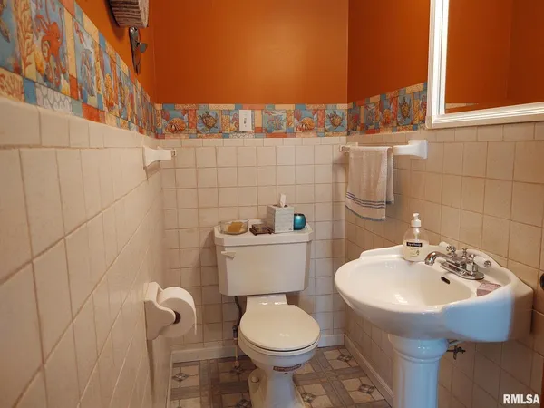 a bathroom with a sink toilet and a mirror