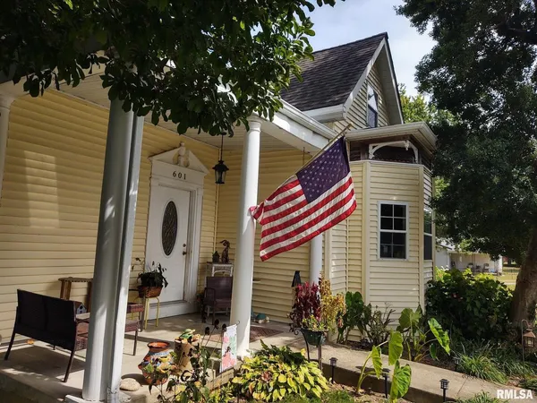 a front view of a house with a tree