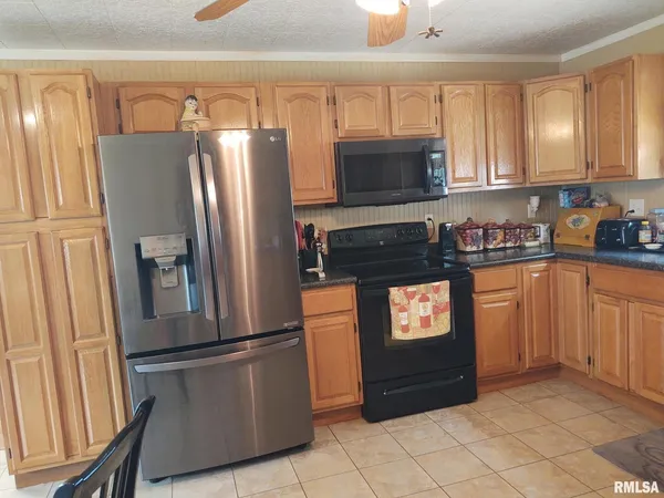 a kitchen with granite countertop a refrigerator and a stove top oven