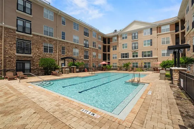 a front view of a building with street view and trees