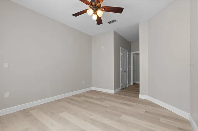 an empty room with closet and a chandelier fan