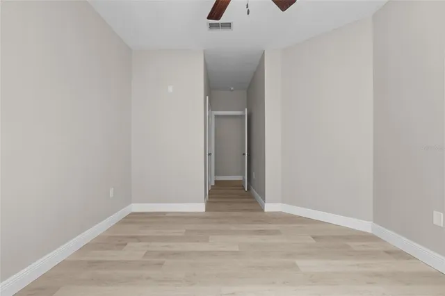 a view of an empty room with wooden floor