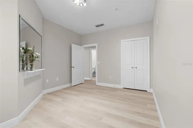 a view of an empty room with window and wooden floor