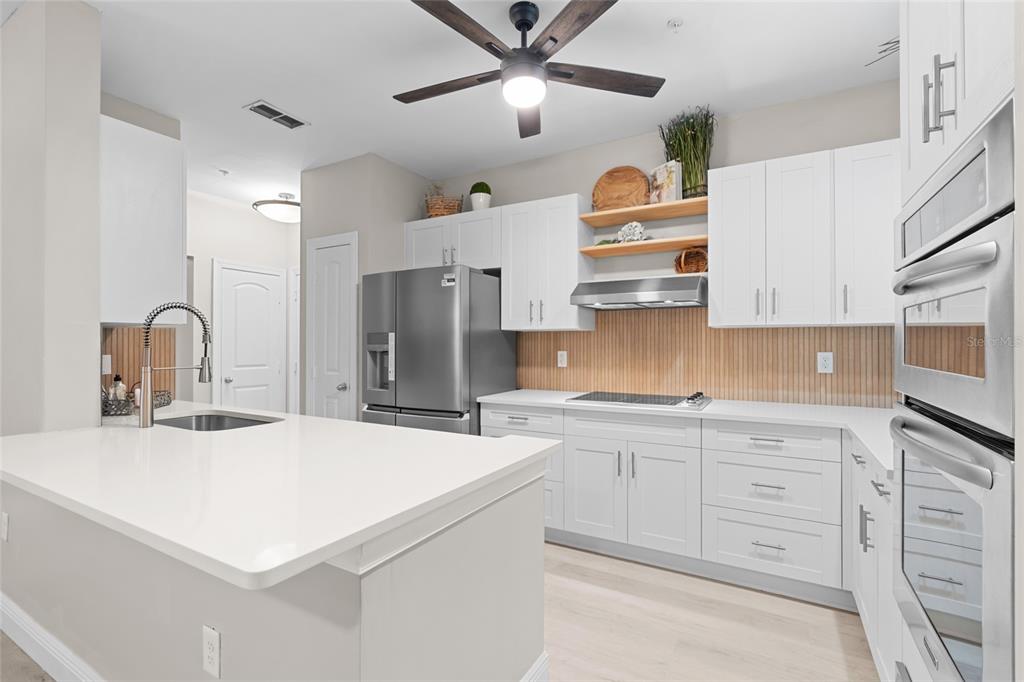 4221 West Spruce Street, Unit 1108 Tampa, FL 33607 - Photo 10 of 31 a kitchen with kitchen island a sink stainless steel appliances and cabinets