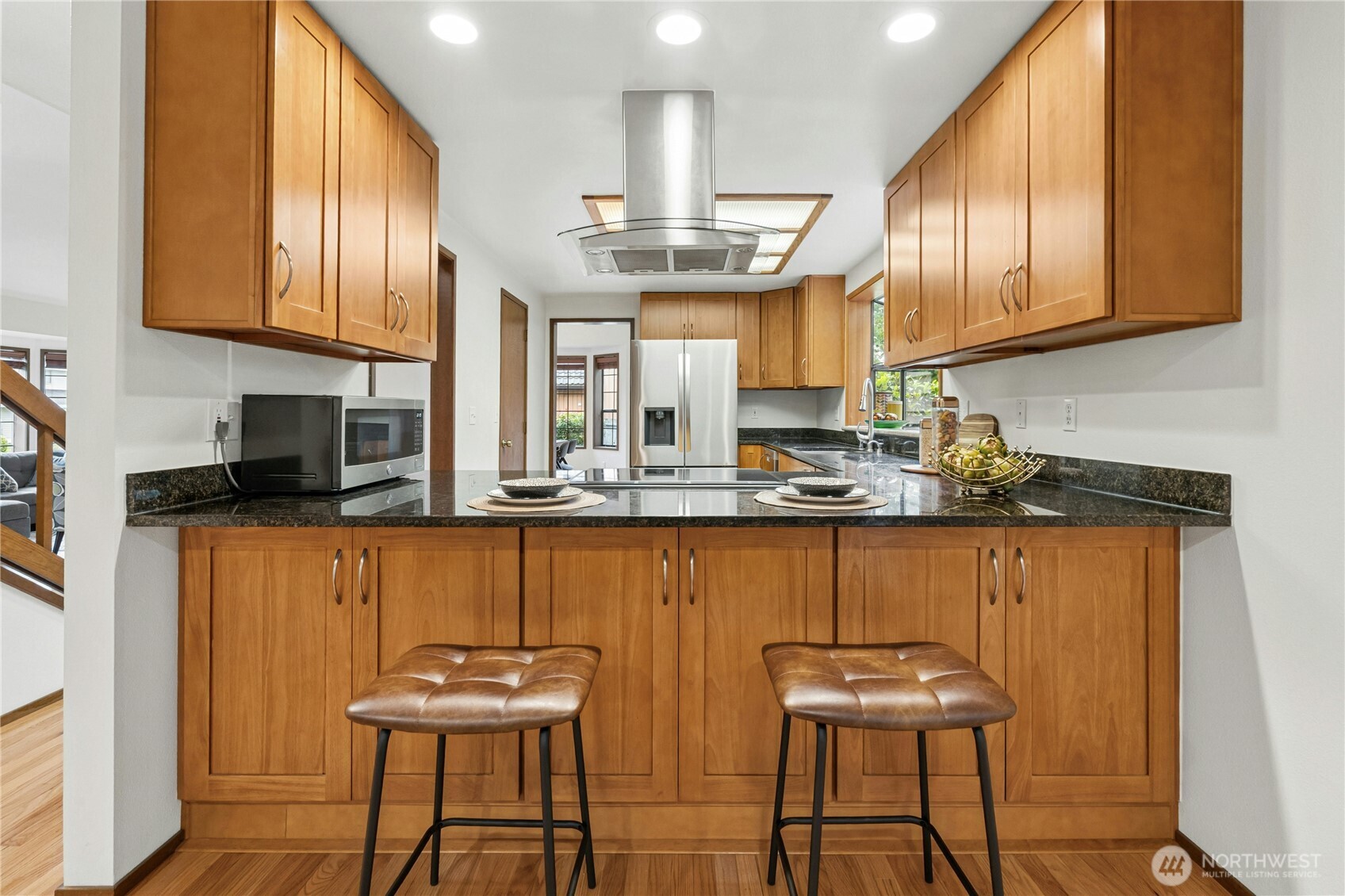 5211 103rd Street Southwest, Unit SW Mukilteo, WA 98275 - Photo 10 of 40 a kitchen with stainless steel appliances granite countertop wooden cabinets a refrigerator a stove and a sink with wooden floor