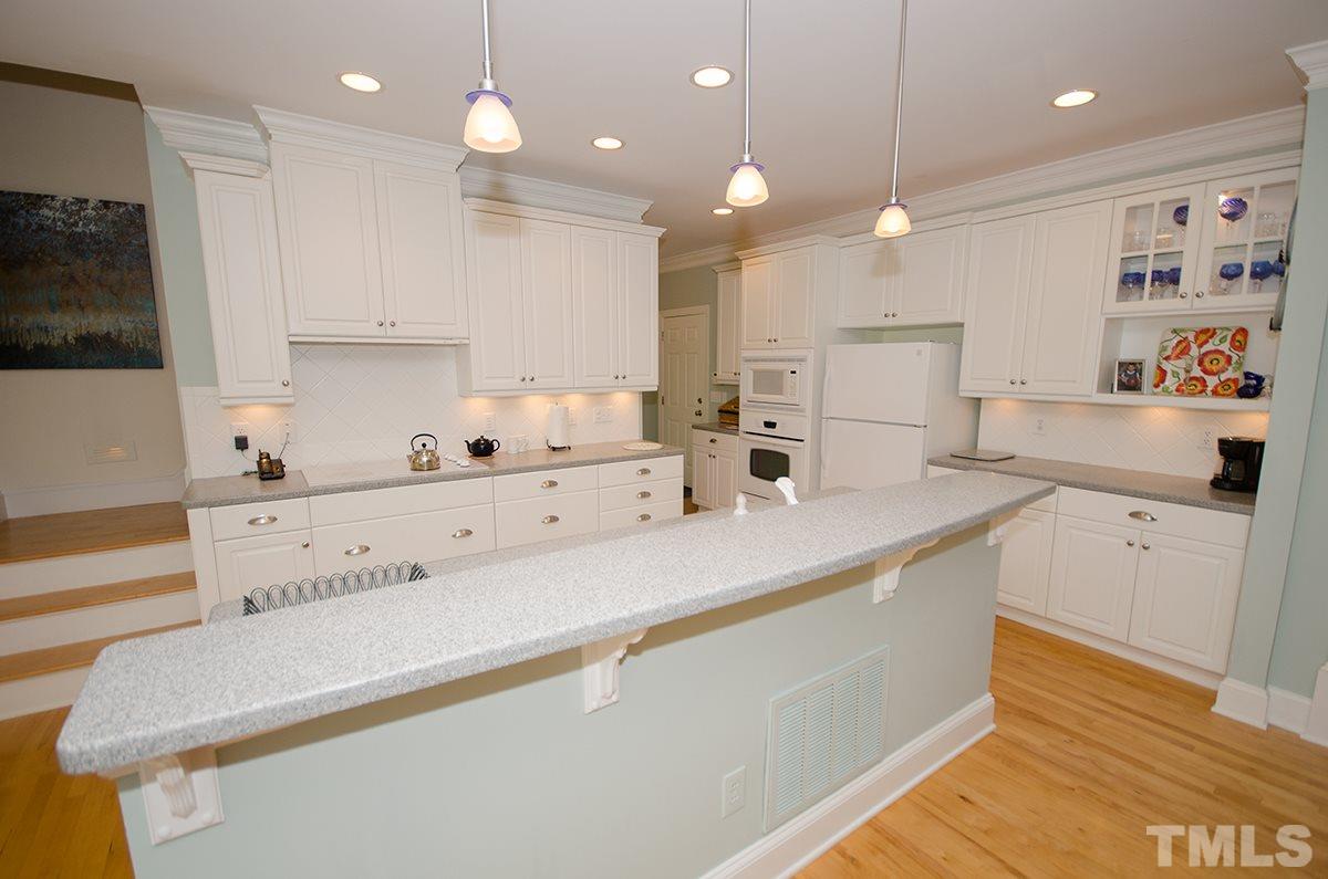1106 Stanridge Drive Raleigh, NC 27613 - Photo 12 of 24 a kitchen with kitchen island white cabinets and refrigerator