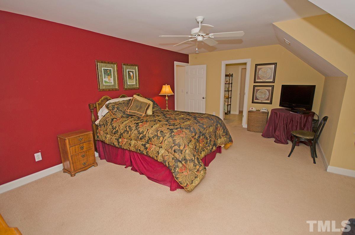 1106 Stanridge Drive Raleigh, NC 27613 - Photo 16 of 24 a bedroom with a bed and a chandelier
