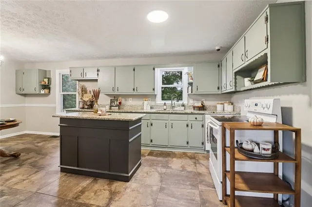 a kitchen with stainless steel appliances granite countertop a sink a stove and a wooden floors