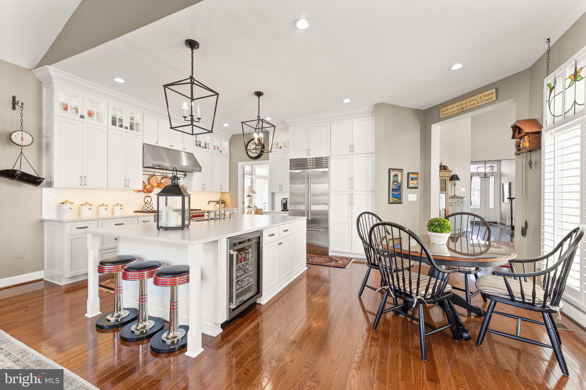 43524 Jackson Hole Circle Leesburg, VA 20176 - Photo 19 of 149 a kitchen with stainless steel appliances kitchen island granite countertop a table chairs and a wooden floor