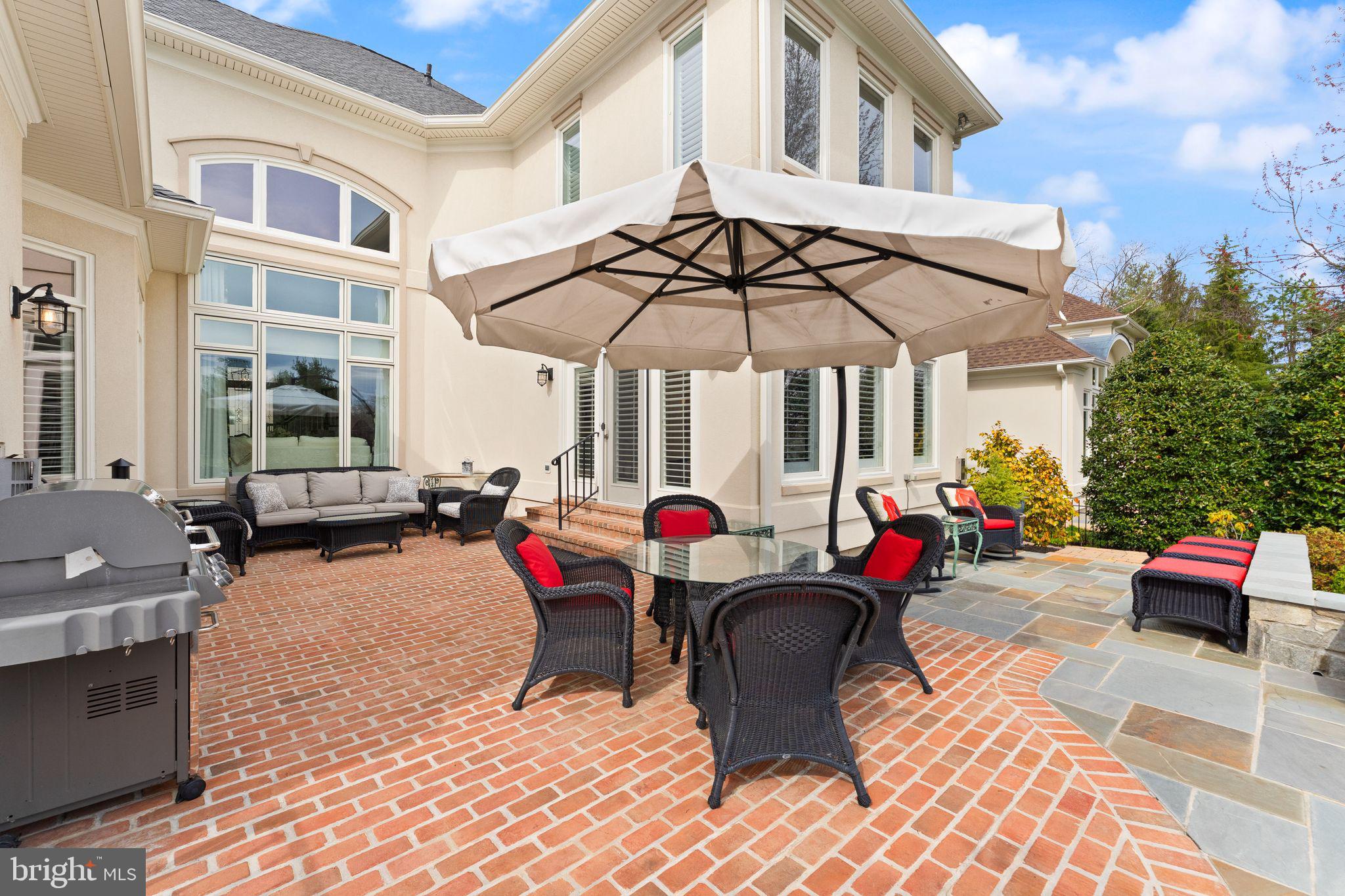 43524 Jackson Hole Circle Leesburg, VA 20176 - Photo 88 of 149 a view of a patio with dining table and chairs under an umbrella