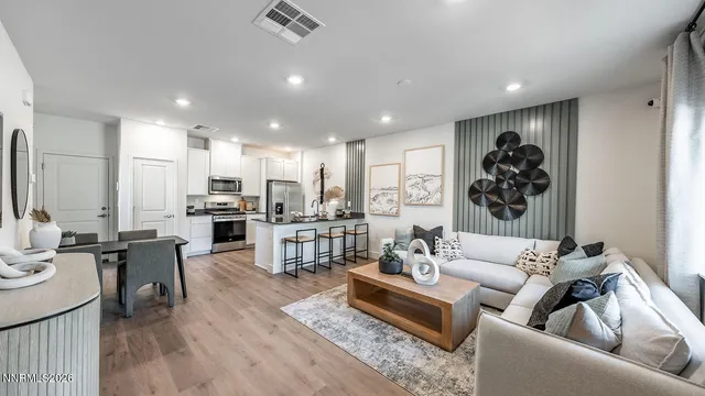a living room with lots of furniture and kitchen view