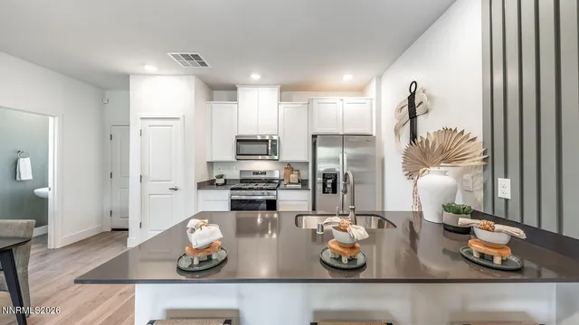 a kitchen with stainless steel appliances kitchen island granite countertop a stove a refrigerator and cabinets