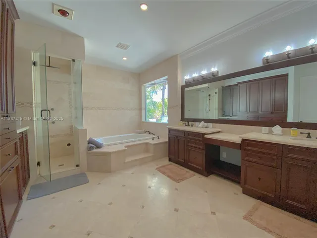 a bathroom with a tub sink shower double vanity