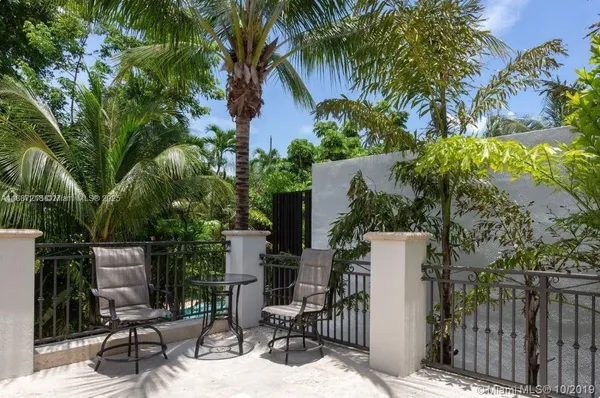 a view of backyard with outdoor seating and plants