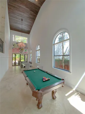 a room with pool table and windows
