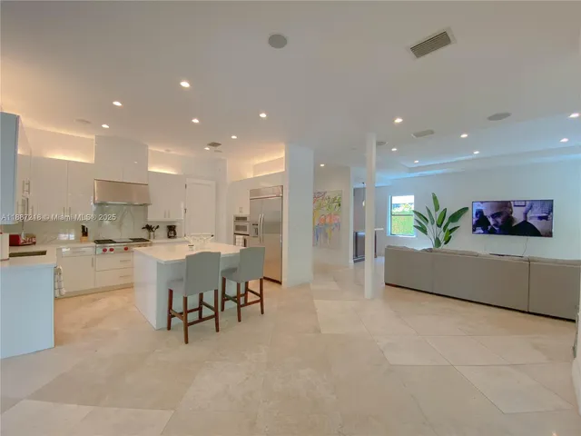 a living room with furniture and kitchen view