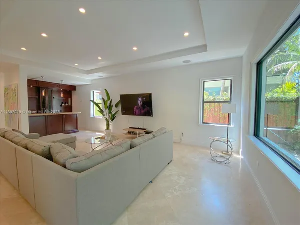 a living room with kitchen furniture and a flat screen tv