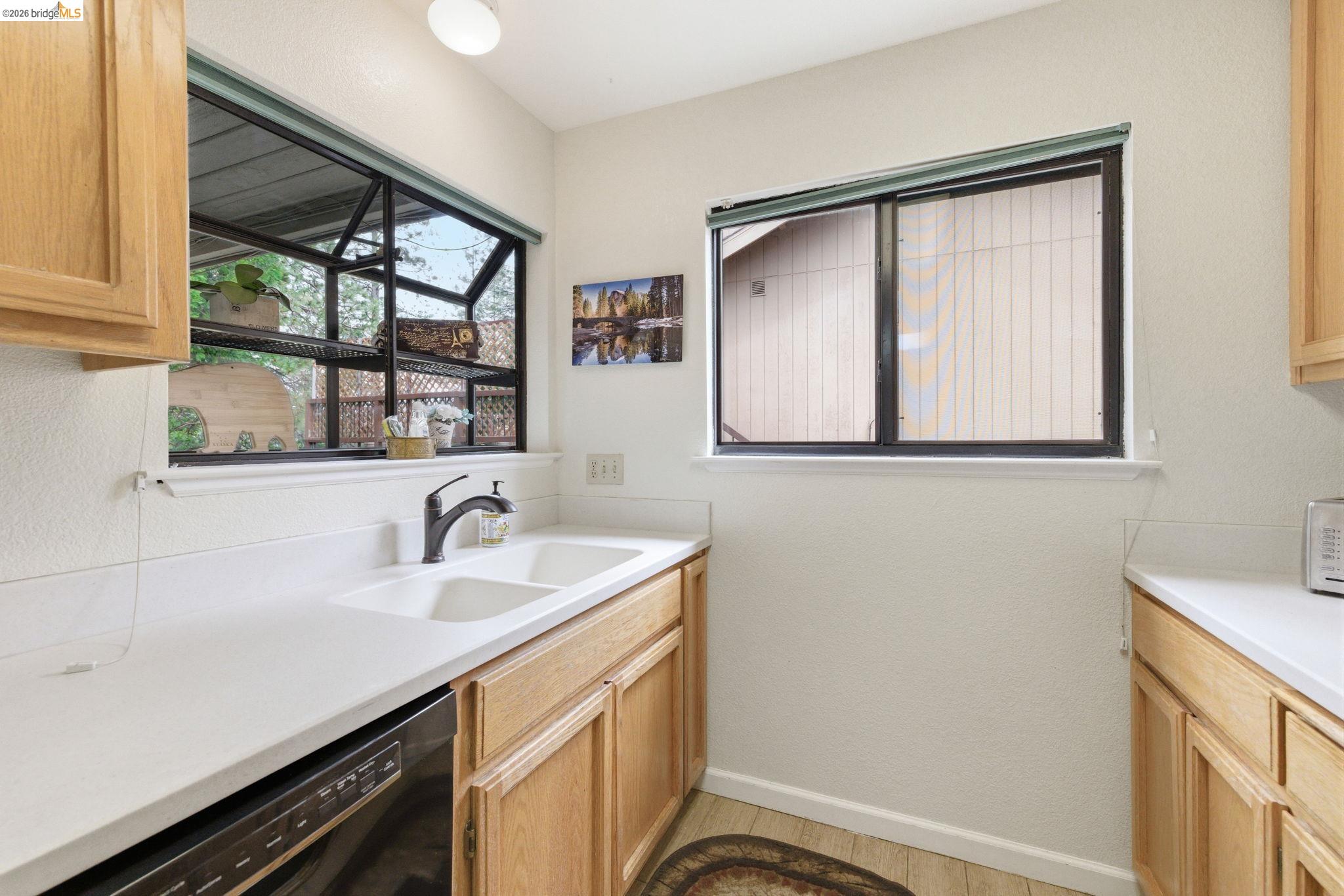 12068 Breckenridge Road Groveland, CA 95321 - Photo 21 of 55 Kitchen featuring dishwasher, light wood finish cabinetry, and a textured wall