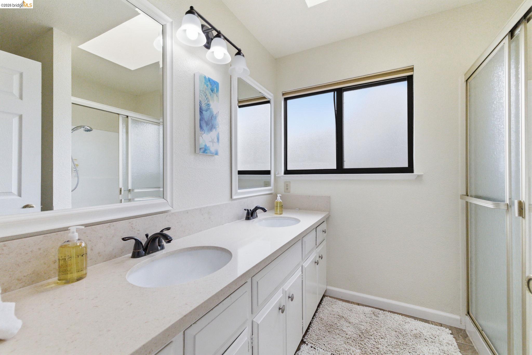 12068 Breckenridge Road Groveland, CA 95321 - Photo 26 of 55 Full bath featuring a skylight, double vanity, and a stall shower