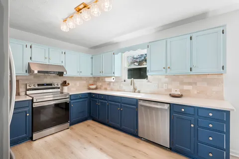 a kitchen with stainless steel appliances granite countertop a sink and cabinets