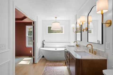 a bathroom with a double vanity sink mirror and bathtub