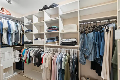 a view of walk in closet with clothes and shoes