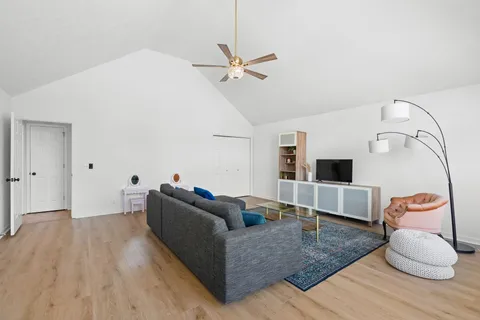 a living room with furniture and a wooden floor