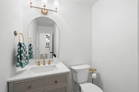 a bathroom with a sink mirror vanity and toilet