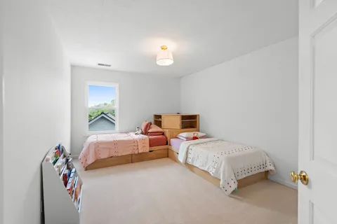 a bedroom with two beds and a potted plant