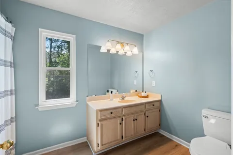 a spacious bathroom with a toilet sink and mirror