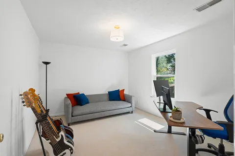 a living room with furniture a air conditioner and a window