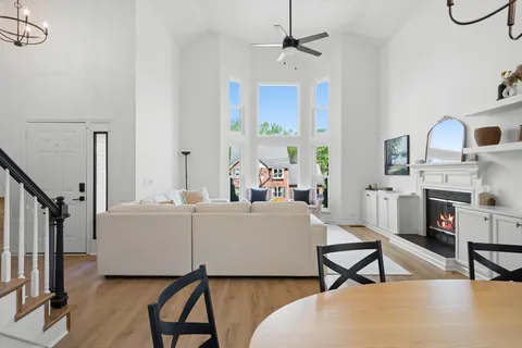 a living room with furniture a flat screen tv and a window