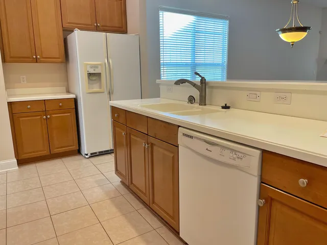 a kitchen with a sink a refrigerator and cabinets