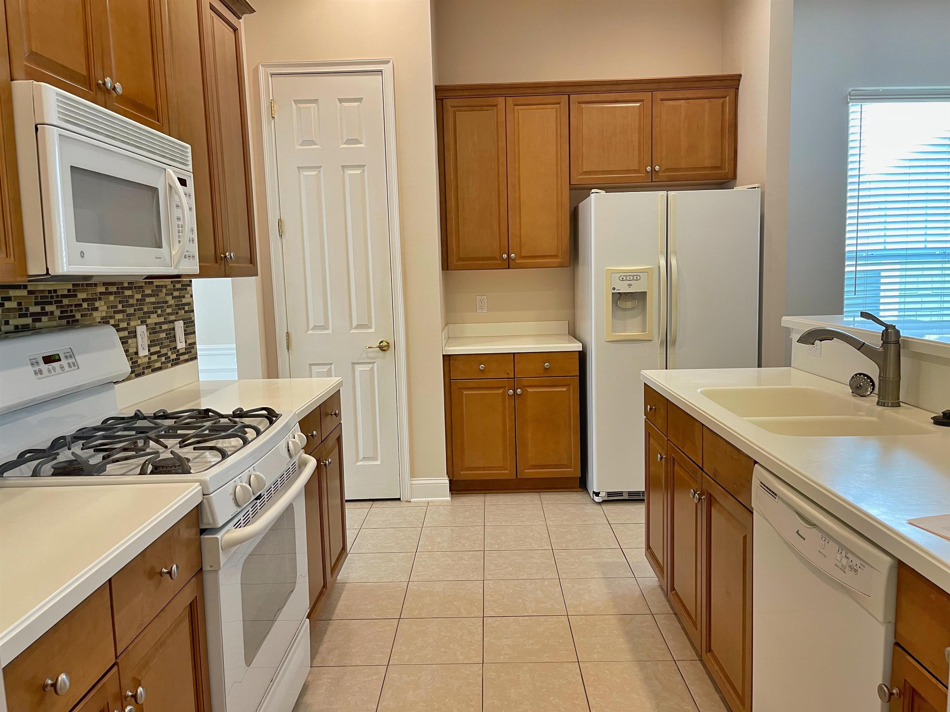 157 West Village Drive St. Augustine, FL 32095 - Photo 9 of 43 a kitchen with a stove a refrigerator and a sink