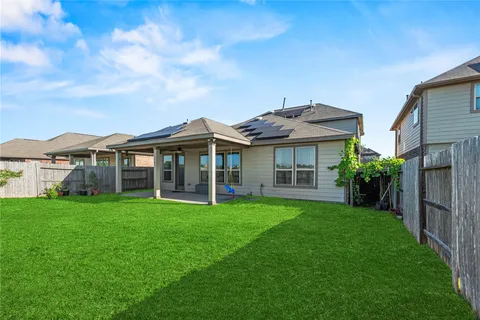 a view of a house with a big yard and large trees