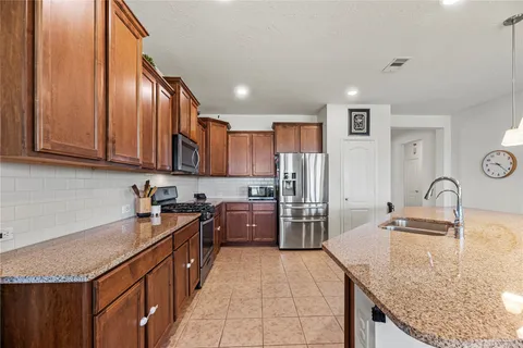 a kitchen with stainless steel appliances granite countertop a sink stove and refrigerator