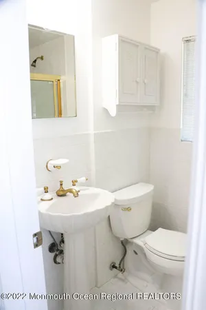 a bathroom with a sink toilet and mirror