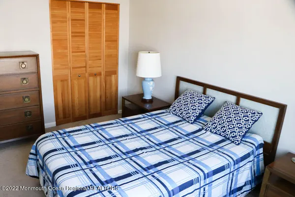 a bedroom with a bed and a lamp on dresser