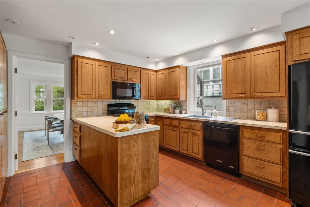 16 Duxbury Road Newton, MA 02459 - Photo 13 of 30 a kitchen with stainless steel appliances granite countertop a stove top oven a sink dishwasher a refrigerator and a dining table with wooden cabinet
