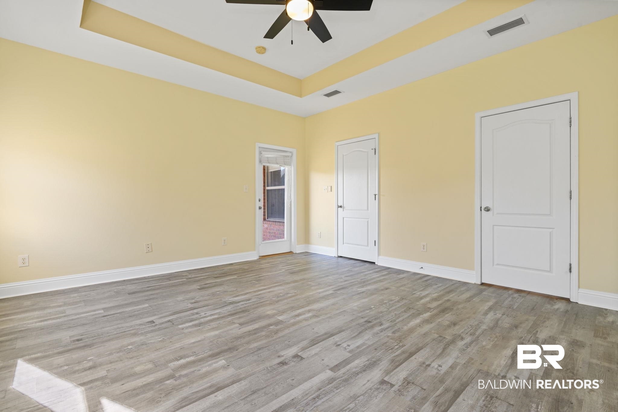 25234 Fairfax Road Daphne, AL 36526 - Photo 26 of 45 Unfurnished bedroom with a raised ceiling, light wood-style floors, and ceiling fan