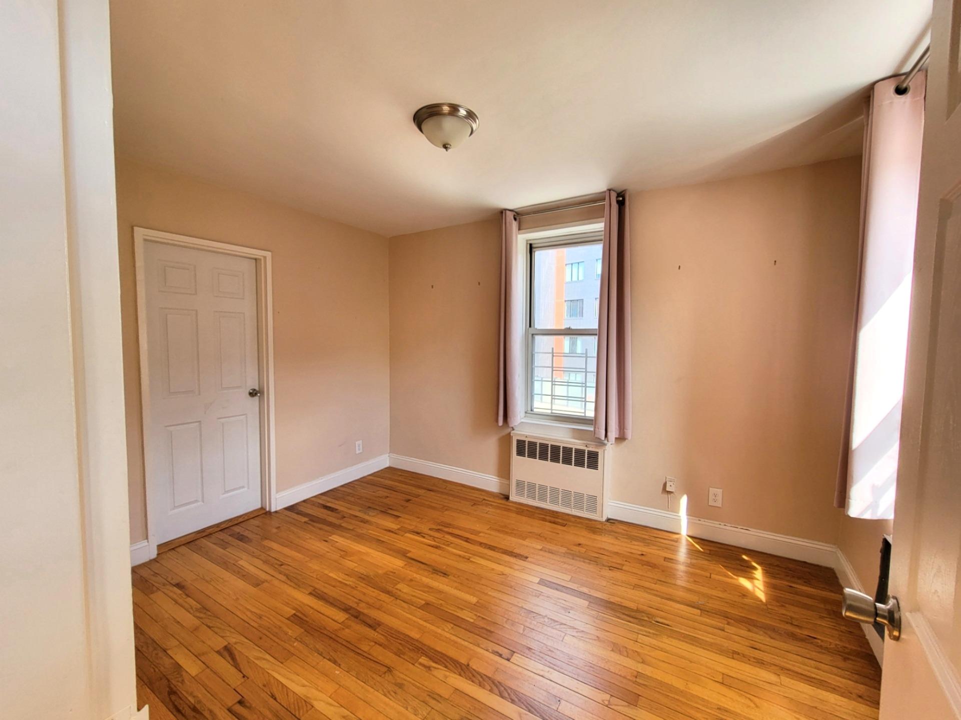 2736 Independence Avenue, Unit 4C Bronx, NY 10463 - Photo 7 of 8 Spare room with radiator heating unit, light wood finished floors, and baseboards