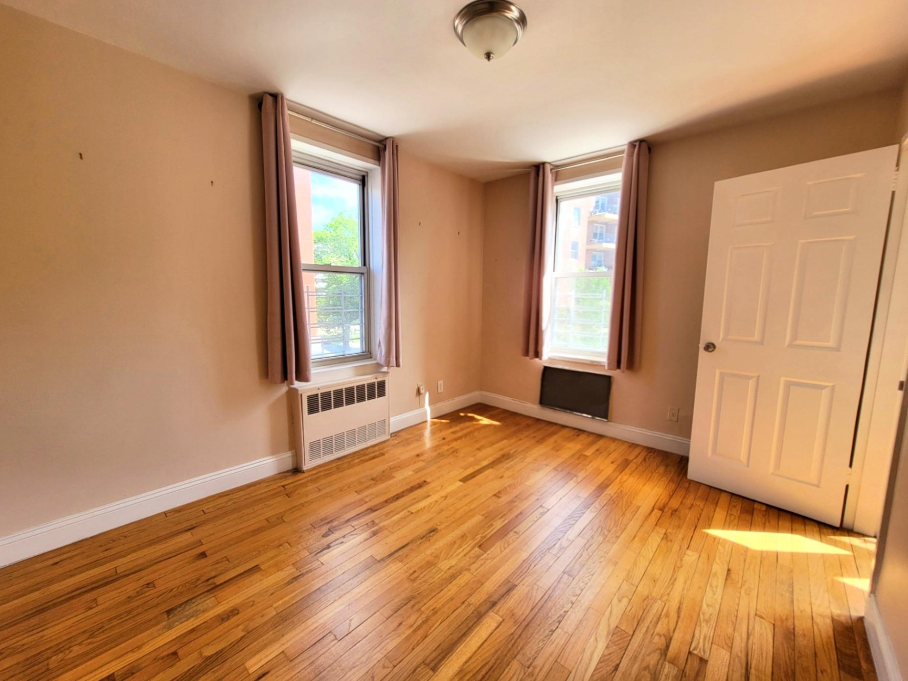 2736 Independence Avenue, Unit 4C Bronx, NY 10463 - Photo 8 of 8 Unfurnished room with radiator, light wood finished floors, and baseboards