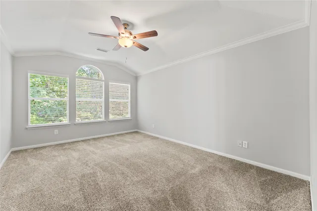 an empty room with a window and a fan