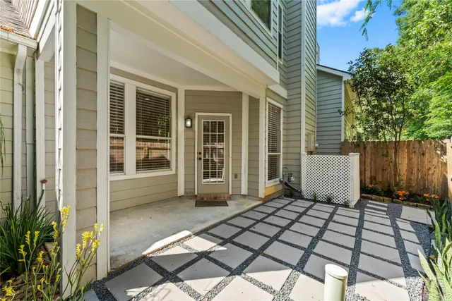 a view of backyard with large trees and wooden fence