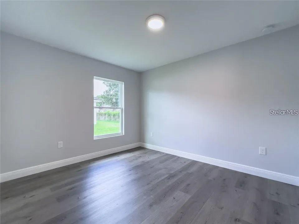 6688 Cherry Road Ocala, FL 34472 - Photo 4 of 9 a view of an empty room with wooden floor and a window