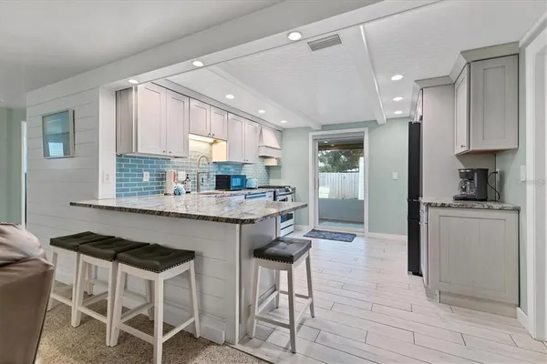 a kitchen with granite countertop wooden cabinets and refrigerator