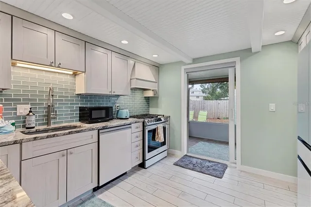 a kitchen with granite countertop a sink stainless steel appliances and cabinets